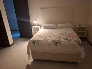 a bedroom with a bed with a white comforter at Suíte Tranquila em Ambiente Familiar em Antares in Maceió