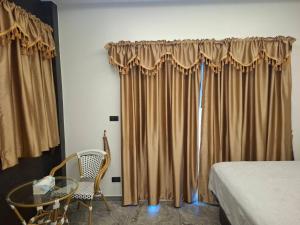 a bedroom with curtains and a glass table and a bed at Villa Meerblick in Ban Map Khangkhao