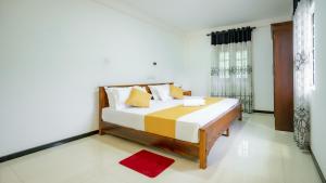 a bedroom with a bed and a window at Villa Amora Hikkaduwa in Hikkaduwa