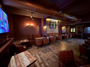 a restaurant with tables and chairs and a large screen at Hotel Alka Residency in Thane