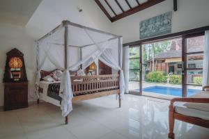 a bedroom with a canopy bed and a swimming pool at Frangipani Beach Hotel in Lovina +99 photos