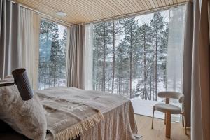 a bedroom with a bed and a large window at Inai Haven in Ivalo