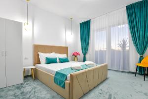 a bedroom with a large bed with blue accents at Vila Manuela Techirghiol in Techirghiol