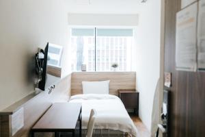 a bedroom with a bed and a table and a window at Meworld Hotel - Daan in Taipei +48 photos