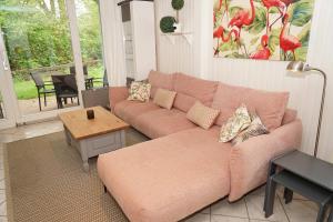 a living room with a couch and a table at Blockhaus mit grosser überdachter Terrasse in Damp +9 photos