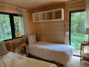 a bedroom with two beds in a log cabin at Les Ecolodges du Lac in Chambon-sur-Lac