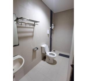 a bathroom with a toilet and a sink at Hotel O Pavilion Inn Hotel in Lumut +37 photos