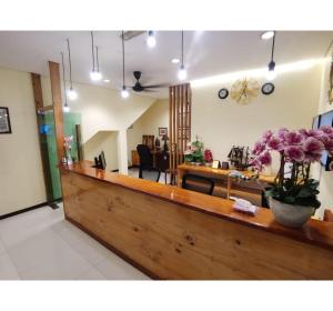 a lobby with a counter with flowers on it at Hotel O Pavilion Inn Hotel in Lumut