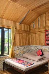 a large bed in a room with a wooden ceiling at Y Sao Homestay in Hòa Bình