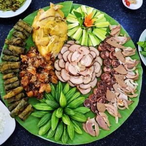 a green plate with different types of food on it at Y Sao Homestay in Hòa Bình