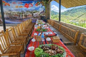 a long table with plates of food on it at Y Sao Homestay in Hòa Bình