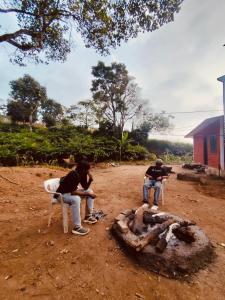 two people sitting in chairs next to a bonfire at Westernmagic in Idukki