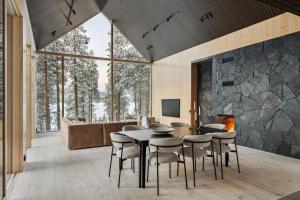 a living room with a table and chairs and a stone wall at Inai Haven in Ivalo