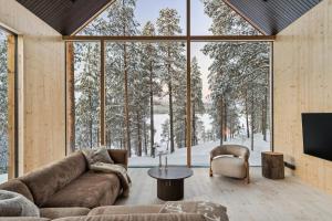 a living room with a couch and a large window at Inai Haven in Ivalo