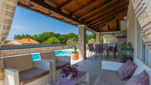 a patio with furniture and a swimming pool at Villa Melnica by Villas Guide in Barban