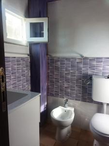a bathroom with a white toilet and a sink at ECO Affittacamere Casa Maica Eco guesthouse in Stintino +32 photos