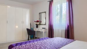 a bedroom with a purple bed and a window at Villa Melnica by Villas Guide in Barban +29 photos
