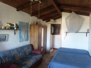 a living room with a couch and a blue bed at ECO Affittacamere Casa Maica Eco guesthouse in Stintino