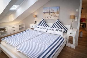 a bedroom with a large bed with blue and white stripes at Seesucht-Hohwacht - Grosse Ferienwohnung im Beachhouse-Stil, 2 Balkone, 2 SZ und nur 300m zum Strand in Hohwacht