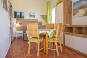 a kitchen and dining room with a table and chairs at Apartements Magdalena in Lopar