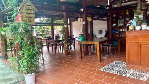 a restaurant with wooden tables and chairs and plants at Sam Ong Lang Homestay in Phú Quốc +44 photos