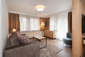 a living room with a couch and a chair at Hotel Grindelwalderhof in Grindelwald