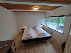 ein Zimmer mit einem großen Bett in einem Zimmer mit Fenster in der Unterkunft Fjeldgaard - Aarup in Årup