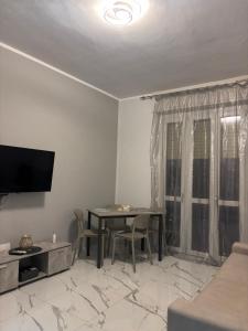 a living room with a dining room table and a television at GioNi HOUSE in Collegno