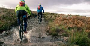 two people riding bikes down a dirt trail at The Brackenrigg Inn in Watermillock