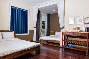 a bedroom with two beds and a mirror at Olive Villa in Khu Chi Lăng
