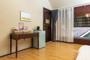 a room with a desk and a refrigerator and a window at Olive Villa in Khu Chi Lăng +1 photo