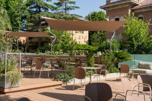 a patio with tables and chairs on a wooden deck at Hotel Aria in Rimini