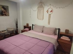 a bedroom with a bed with a purple comforter at Private Rooms in shared house in Thessaloniki