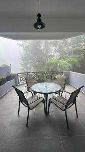 a table and chairs on a balcony with a table and chairs at Fraser's Haven SilverparkResort Walk down 8 steps in Bukit Fraser