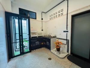 a kitchen with a sink and a door with a vase at Sleep at Saithai in Ban Sai Thai