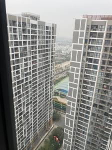 a view of two tall buildings from a window at Dulichxanh3026 in Gia Lâm Pho