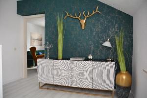 a living room with a table with plants on a wall at Appartement am Diemelsee Infrarotsauna inklusive in Marsberg