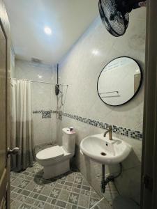 a bathroom with a toilet and a sink and a mirror at Sleep at Saithai in Ban Sai Thai