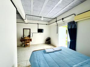 a bedroom with a blue bed and a desk at Bangsaphan Resort in Bang Saphan +107 photos