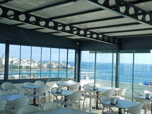 ein Restaurant mit Tischen und Stühlen und Meerblick in der Unterkunft Aykaç Hotel in Silifke