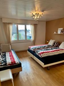 a bedroom with two beds and a chandelier at Grosse Ferienwohnung ideal für Gruppen, nähe Thun und Interlaken in Steffisburg