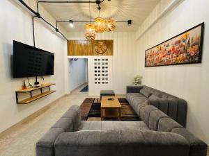 a living room with a couch and a tv at Sleep at Saithai in Ban Sai Thai