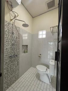a bathroom with a shower and a toilet in it at Heiwana House #1 in Beran-kidul +11 photos