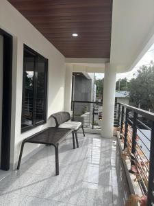 a porch with a bench on a balcony at Heiwana House #1 in Beran-kidul
