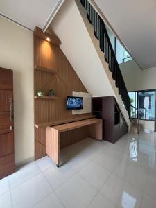 a living room with a tv and a staircase at Heiwana House #1 in Beran-kidul