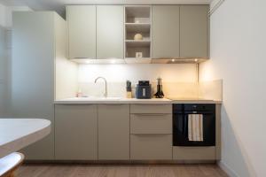 a kitchen with white cabinets and a black oven at Harmony in Arras +10 photos