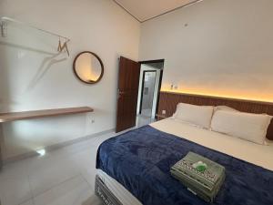 a bedroom with a bed and a mirror on the wall at Heiwana House #1 in Beran-kidul
