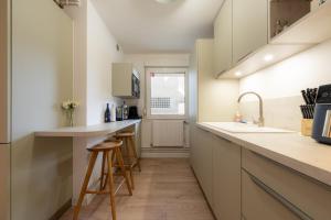 a kitchen with a counter and stools in it at Harmony in Arras