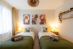 two beds in a room with green and white at Harmony in Arras