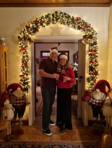 a man and woman standing in front of a doorway with christmas lights at Hotel-Barbarossa-Garni bei Hanau in Rodenbach